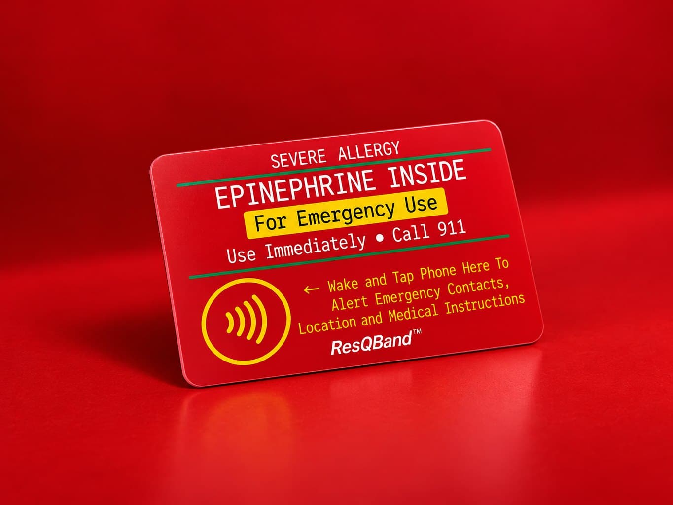 The red ResQBand Tap Card standing on a red studio set: severe allergy, epinephrine inside, for emergency use, use immediately, call 911, wake and tap a phone here to alert emergency contacts, location and medical instructions
